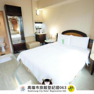 1 dormitorio con 1 cama blanca grande en una habitación en Kindness Hotel Weiwuying en Kaohsiung