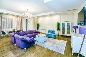 uma sala de estar com um sofá roxo e cadeiras em VIP Apartment MANDARIN em Baku