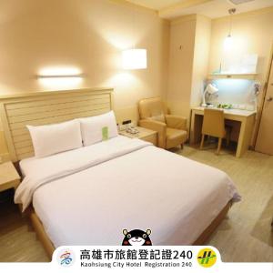 Habitación de hotel con cama y escritorio en Kindness Hotel - Jhong Jheng en Kaohsiung