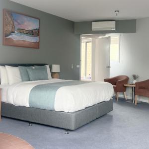 - une chambre avec un grand lit dans l'établissement Waves Luxury Suites, à Port Campbell
