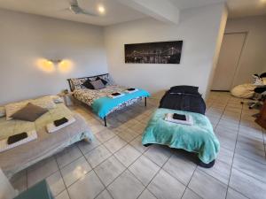 ein Wohnzimmer mit 2 Betten und einem Sofa in der Unterkunft Self Contained Guesthouse for 7ppl, w Pool in Gold Coast
