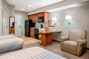 Cette chambre comprend un lit, un bureau et une chaise. dans l'établissement Candlewood Suites LAX Hawthorne, an IHG Hotel, à Hawthorne