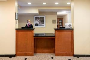 a woman standing at a reception desk at Candlewood Suites LAX Hawthorne by IHG in Hawthorne