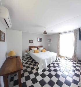 a bedroom with a bed and a checkered floor at Le four à pain in Saint-Philippe