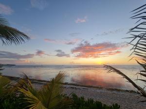 a sunset on a beach with the ocean at Coco Lagon accès plage in Saint-Paul