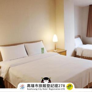 a hotel room with a bed with a teddy bear on it at Kindness Hotel Wu-Jia in Kaohsiung