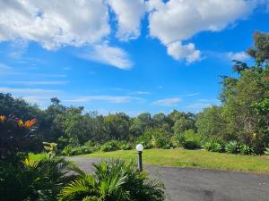 uma cena de rua com um céu azul e árvores em Self Contained Guesthouse for 7ppl, w Pool em Gold Coast