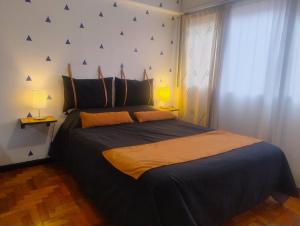 una camera da letto con un grande letto nero con due lampade di Apartment City Heart III a Mendoza