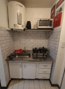 Apartment City Heart III في ميندوزا: مطبخ صغير مع حوض وميكروويف