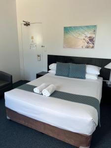 1 dormitorio con 1 cama grande y toallas. en Hotel St Leonards, en Sídney