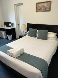 een slaapkamer met een groot bed en handdoeken bij Hotel St Leonards in Sydney