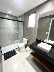 uma casa de banho com um chuveiro, um WC e um lavatório. em Apartamento Grande - Privado - 3 quartos com 1 suíte em Piracicaba