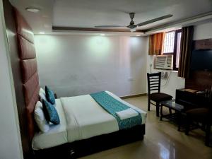 um quarto com uma cama, uma secretária e uma mesa em Hotel Marina Near IGI Airport Delhi em Nova Deli