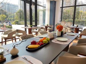 una mesa con una bandeja de fruta en un restaurante en Hangzhou Xiaoshan Airport Lanou International Hotel en Hangzhou