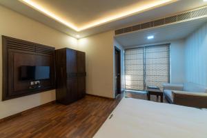 Camera con letto, TV e divano. di Hotel Anmol Bandhan a Jaipur