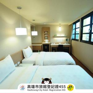 a hotel room with two beds and a desk at Kindness Hotel - Kaohsiung Main Station in Kaohsiung