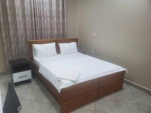 En eller flere senge i et værelse på Mbilinyi Apartments