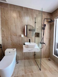 a bathroom with a toilet and a sink and a shower at Legacy Phú Quốc in Phu Quoc