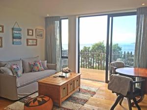 uma sala de estar com um sofá e uma mesa em Wave Song - Waiheke Escapes em Onetangi