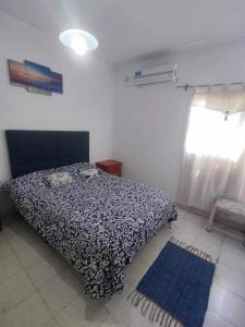 a bedroom with a black and white bed and a window at Hermoso departamento, excelente ubicación in San Fernando del Valle de Catamarca
