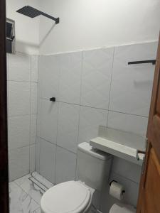 y baño blanco con aseo y ducha. en Hotel Santa Clara, en Belém