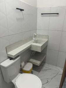 a white bathroom with a sink and a toilet at Hotel Santa Clara in Belém