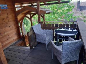 eine Holzterrasse mit Stühlen und einem Tisch auf einer Hütte in der Unterkunft Baumhaus Wolfshöhle in Fischach