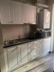 a kitchen with white cabinets and a sink at Home Sweet Home in Braşov