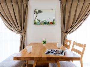 a wooden table with two chairs and a picture on the wall at Comfort Plus in Chatan