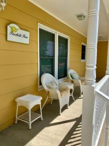 un portico con sedie di vimini e un cartello su una casa di Purcellville Home a Purcellville