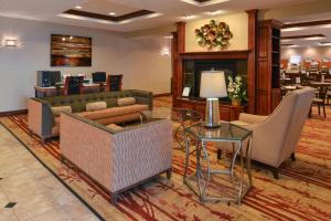 a lobby with couches and a table and chairs at Holiday Inn Express Hotel & Suites Cherry Hills, an IHG Hotel in Omaha