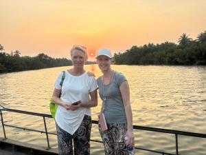 two women standing on a boat on the water at Homestay Bentre Coco Lodge in Ben Tre