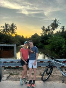 een man en een vrouw die naast een fiets staan bij Bentre Coco Lodge in Ben Tre