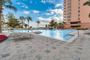 a swimming pool at a resort with chairs and trees at K and J Orlando in Orlando