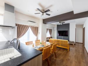 uma cozinha e sala de estar com mesa e cadeiras em Comfort Plus em Chatan