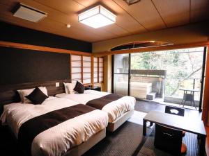 松山的住宿－LiVEMAX RESORT Okudogo，一间卧室设有两张床和大窗户