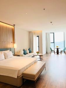 pokój hotelowy z łóżkiem i kanapą w obiekcie Khách sạn A LaCarte Hạ Long - Quảng Ninh w Ha Long