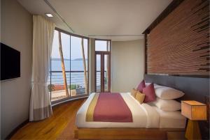 a bedroom with a large bed and a large window at Prana Resort Nandana in Bang Rak Beach