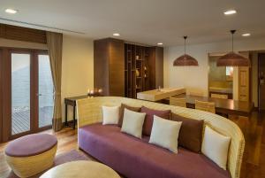 a living room with a couch and a kitchen at Prana Resort Nandana in Bang Rak Beach