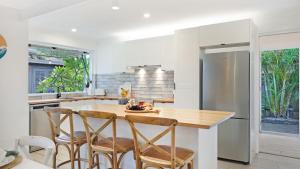 a kitchen with a wooden table and chairs at Shellhaven in Shoalhaven Heads