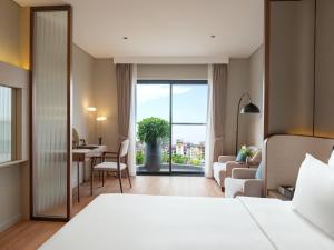 a hotel room with a bed and a living room at CLASSYC Hotel in Hanoi