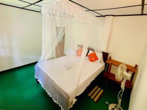 a bedroom with a bed with white mosquito net at Ella Jungle Cottage in Ella