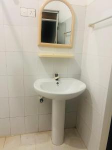 La salle de bains est pourvue d'un lavabo blanc et d'un miroir. dans l'établissement Moxy Bay Arugambay, à Baie d'Arugam