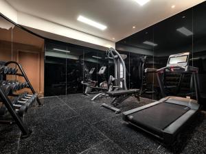 a gym with black walls and tread machines at CLASSYC Hotel in Hanoi