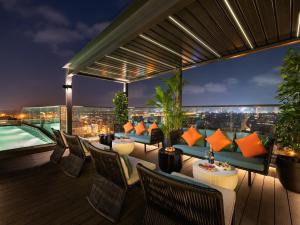 a rooftop deck with a view of the city at night at CLASSYC Hotel in Hanoi