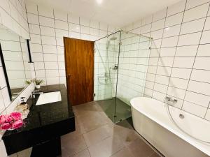 a bathroom with a tub and a sink and a shower at summer pool villa in Laguna Phuket +5 photos