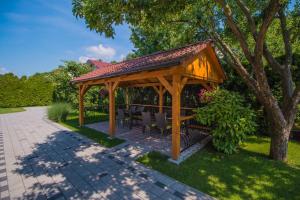 a wooden gazebo with a table and chairs at Pension Danninger in Piešťany