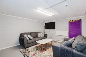 a living room with two couches and a purple door at Blizzard Bunny Lodge 43 Gippsland Street in Jindabyne