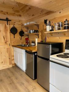 cocina con paredes de madera y horno con fogones en Hillside Haven 1 Bedroom with Hot Tub, en Sussex