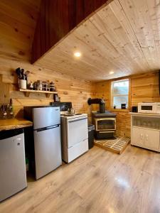 una cocina con electrodomésticos blancos en una cabaña de madera en Hillside Haven 1 Bedroom with Hot Tub, en Sussex